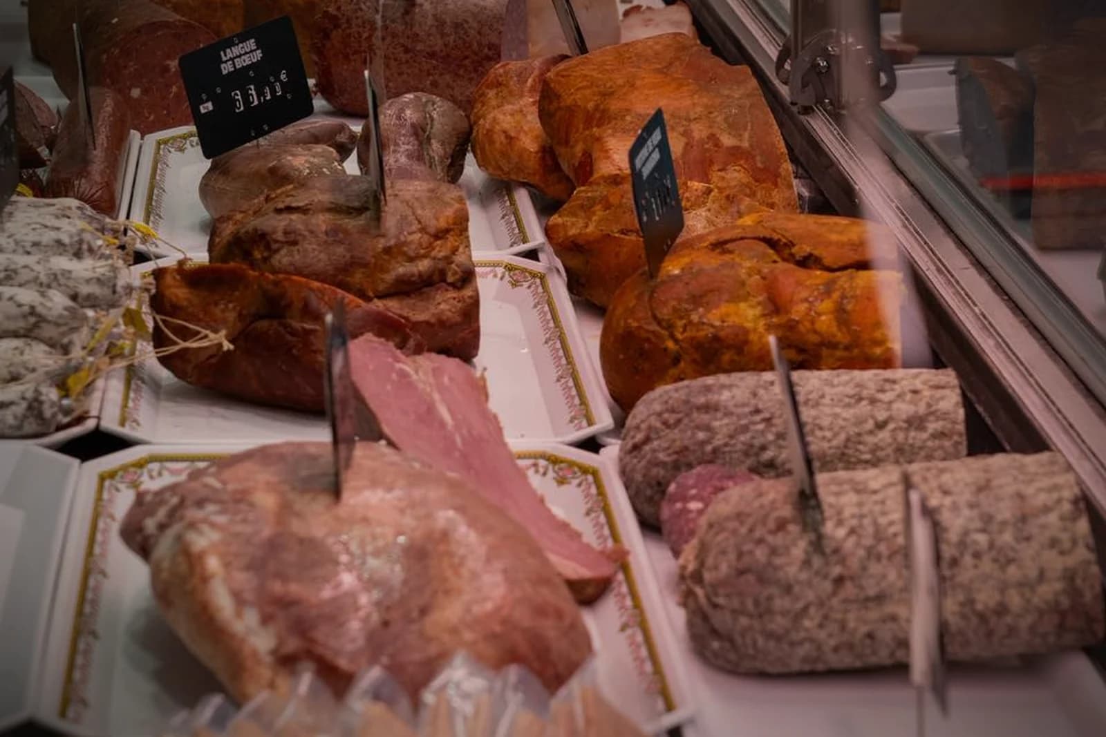 Le comptoir de la charcuterie Panzer, pièces entières étiquetées en vitrine réfrigérée