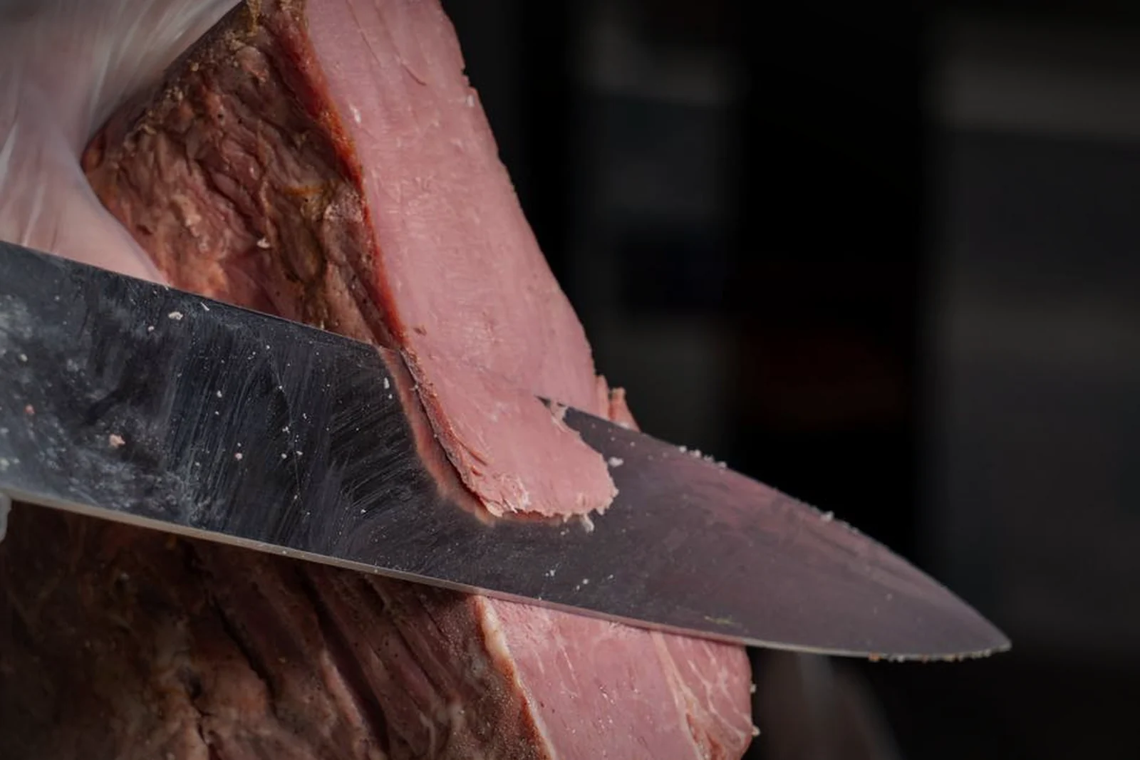 Découpe d'une pièce de pastrami au couteau, à la charcuterie Panzer